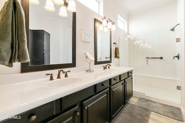 bathroom featuring a sink, a shower stall, and crown molding