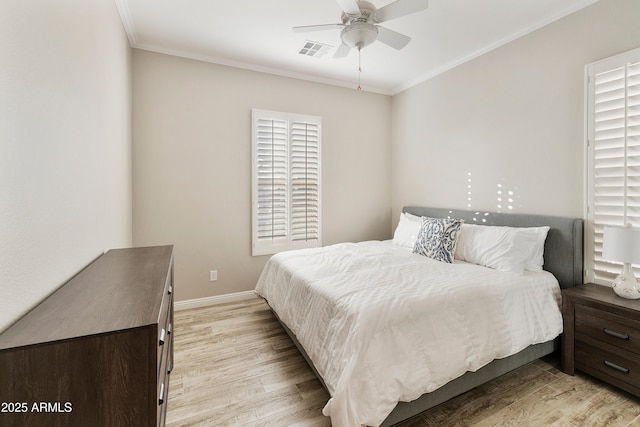 bedroom with light wood finished floors, visible vents, ceiling fan, baseboards, and ornamental molding