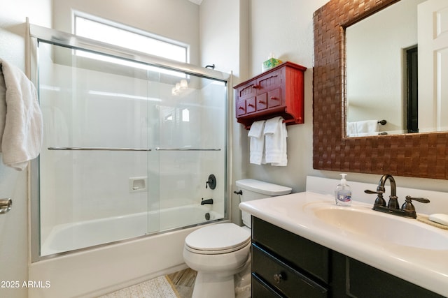 full bath featuring toilet, vanity, and bath / shower combo with glass door