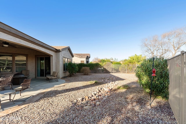 view of yard with ceiling fan, a patio, and a fenced backyard