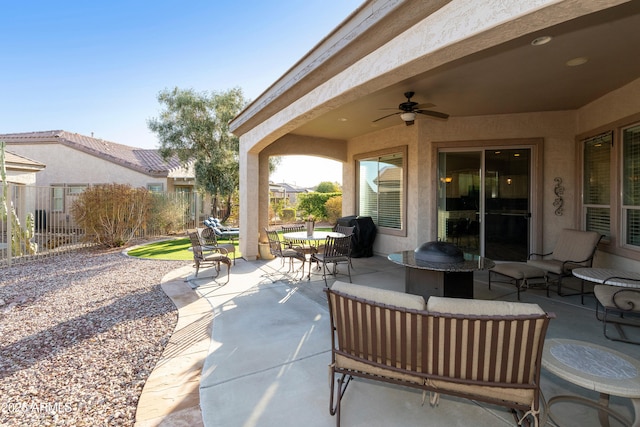 view of patio featuring outdoor dining space, ceiling fan, and fence