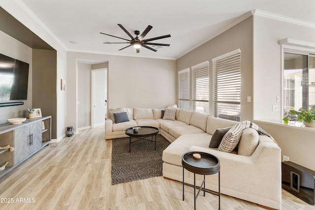 living room featuring crown molding, baseboards, light wood-type flooring, and ceiling fan