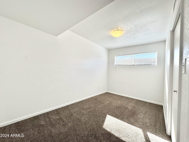 carpeted spare room featuring a textured ceiling