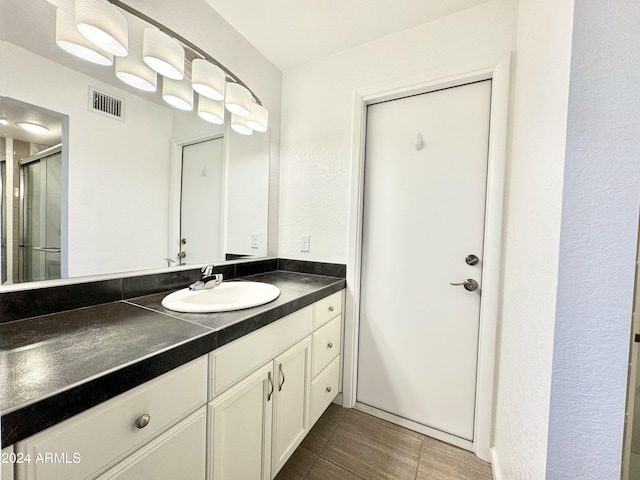 bathroom featuring tile patterned floors, vanity, and walk in shower