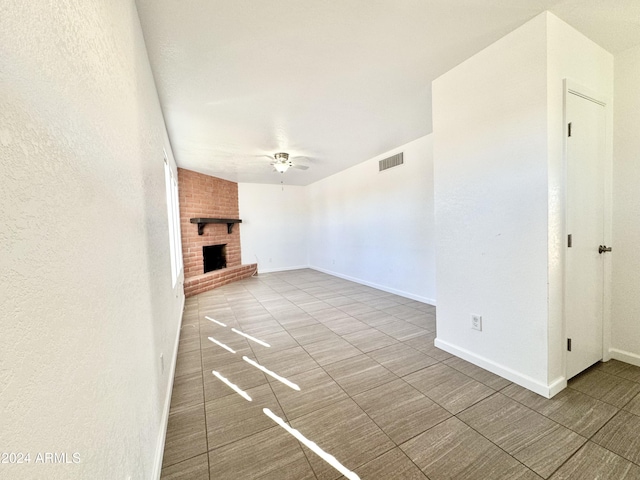 unfurnished living room featuring ceiling fan and a fireplace