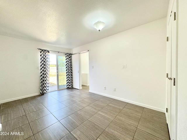 unfurnished room featuring a textured ceiling