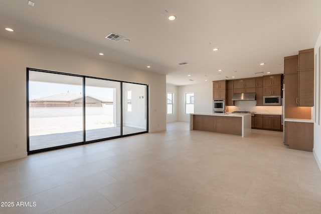 24022 S 218th Pl, Queen Creek, AZ 85142 - kitchen with stainless steel appliances, under cabinet range hood, light countertops, open floor plan, and an island with sink