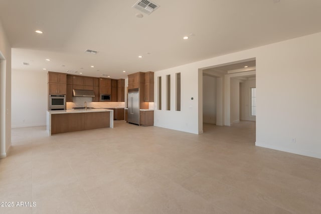 24022 S 218th Pl, Queen Creek, AZ 85142 - kitchen with stainless steel appliances, open floor plan, recessed lighting, brown cabinets, and light countertops