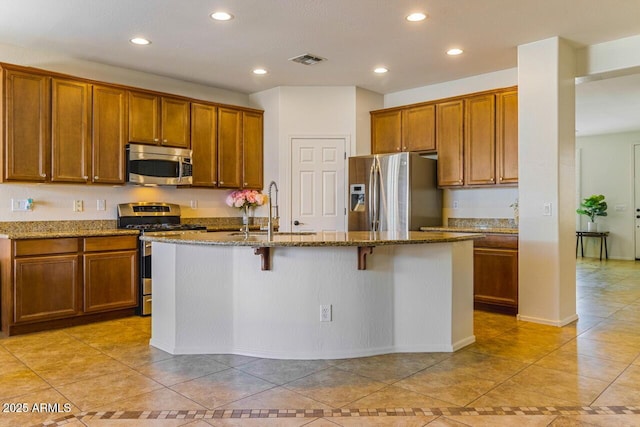 16559 W Lincoln St, Goodyear, AZ 85338 - kitchen featuring stainless steel appliances, brown cabinets, light tile patterned flooring, and recessed lighting