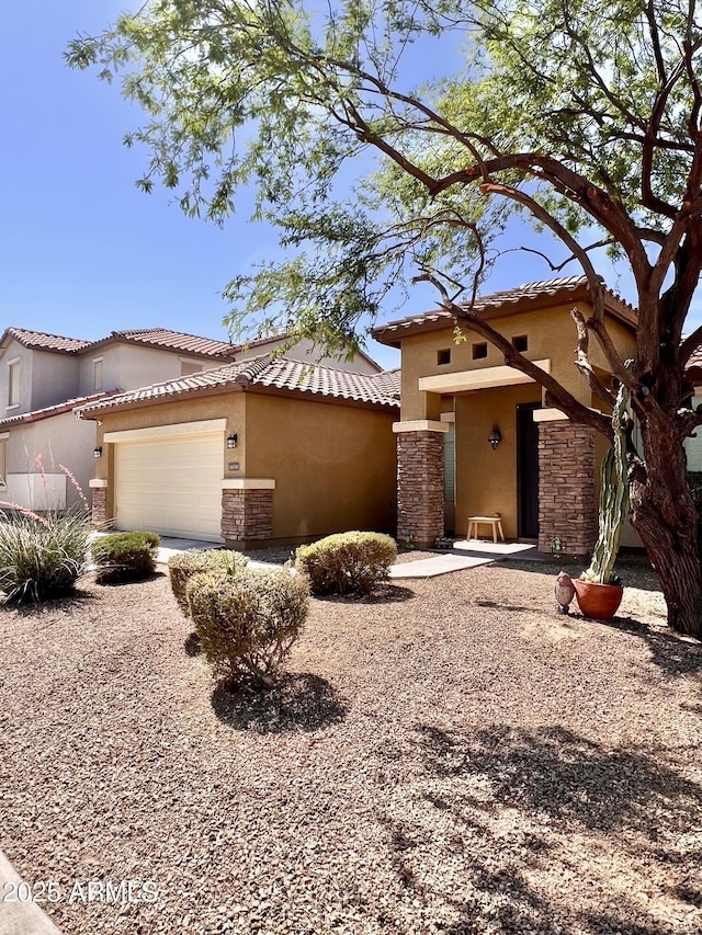 16559 W Lincoln St, Goodyear, AZ 85338 - mediterranean / spanish home featuring stucco siding, stone siding, an attached garage, and a tile roof