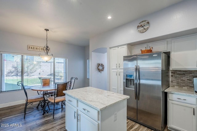 kitchen with pendant lighting, a center island, tasteful backsplash, white cabinets, and stainless steel fridge with ice dispenser