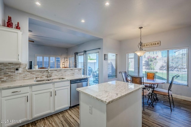 kitchen featuring dishwasher, hanging light fixtures, sink, white cabinets, and a center island