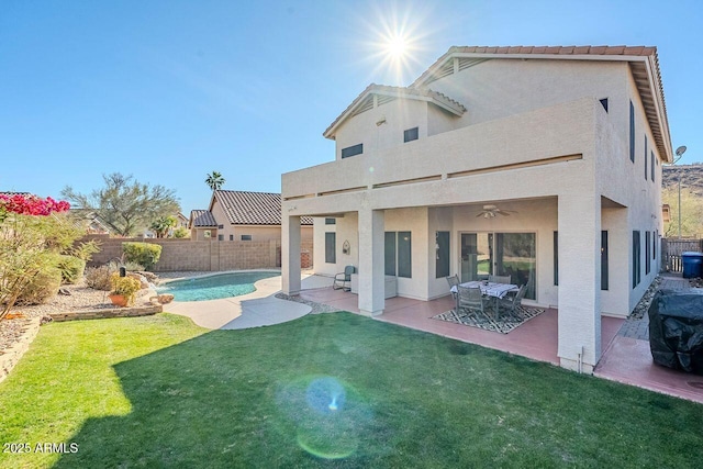 back of property featuring a fenced in pool, a patio area, a lawn, and ceiling fan