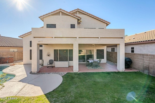 rear view of property featuring a patio, a balcony, ceiling fan, and a yard