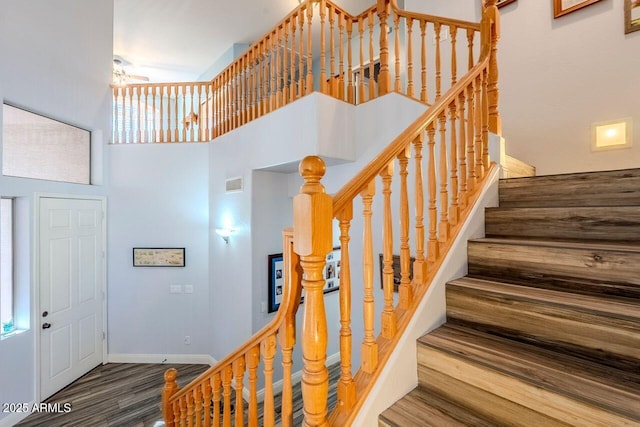 stairs featuring a high ceiling and hardwood / wood-style floors