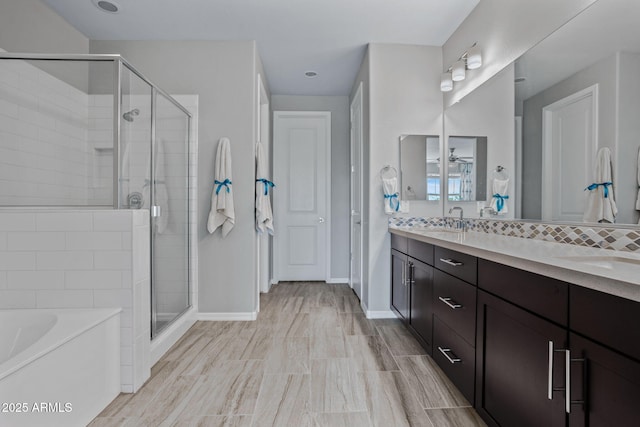 full bath with tasteful backsplash, double vanity, a stall shower, a bath, and a sink