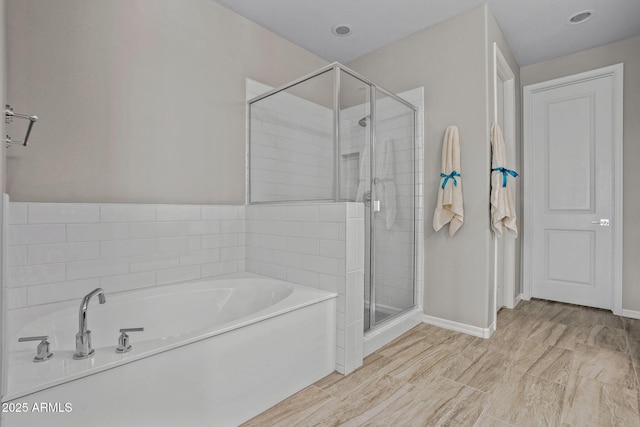 full bath featuring a shower stall and a garden tub