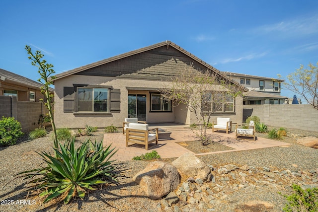 back of property with a patio area, an outdoor living space, a fenced backyard, and stucco siding