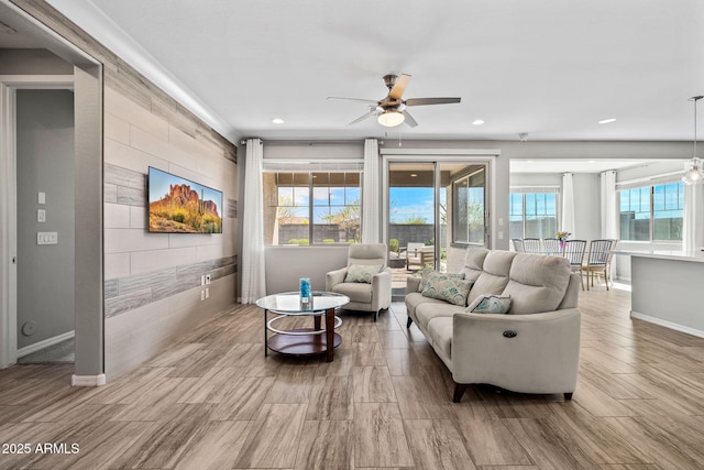 living area featuring a ceiling fan, wood finished floors, recessed lighting, baseboards, and an accent wall