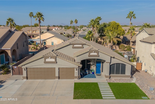 view of front facade featuring stucco siding, concrete driveway, a garage, a residential view, and a tiled roof