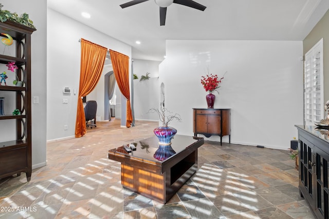 living room featuring recessed lighting, stone finish floor, ceiling fan, and baseboards