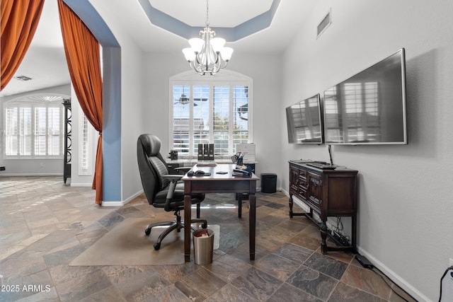 office area featuring visible vents, a tray ceiling, stone tile flooring, and baseboards