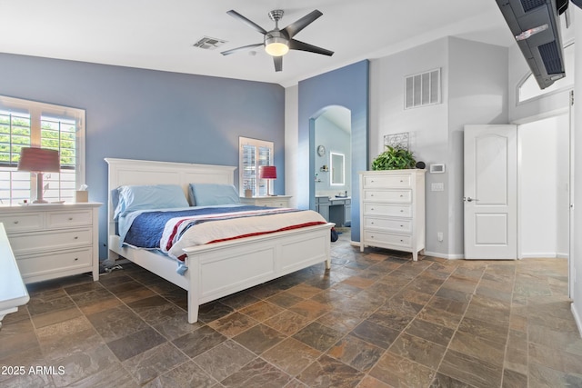 bedroom with stone finish floor, ceiling fan, visible vents, and baseboards
