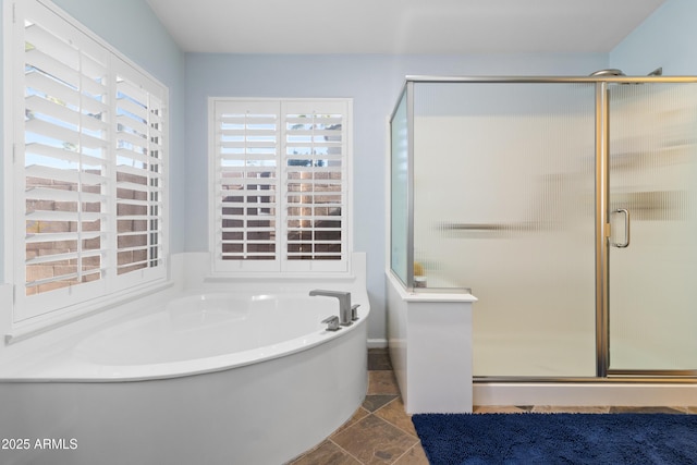 bathroom featuring stone finish floor, a garden tub, and a shower stall