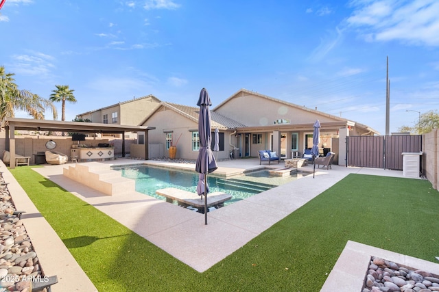 view of pool featuring an outdoor kitchen, a fenced backyard, an outdoor hangout area, a gate, and a patio area
