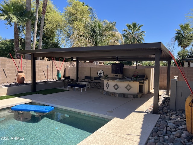 view of swimming pool featuring an outdoor kitchen, a fenced backyard, an outdoor hangout area, a fenced in pool, and a patio area