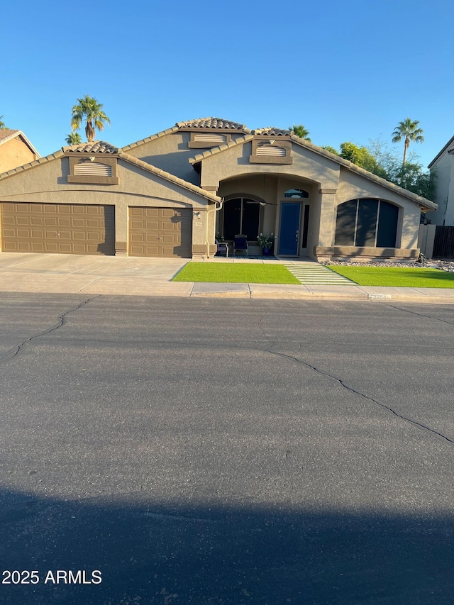 view of front facade featuring a garage, driveway, and stucco siding