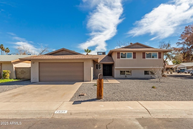 tri-level home with concrete driveway and an attached garage