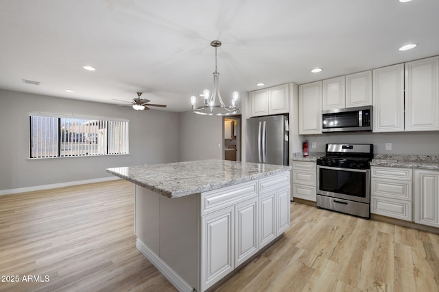 kitchen with appliances with stainless steel finishes, white cabinetry, visible vents, and light wood-style floors