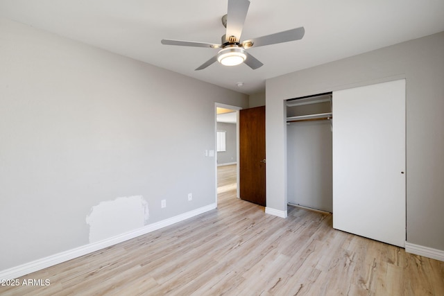 unfurnished bedroom featuring light wood finished floors, ceiling fan, baseboards, and a closet