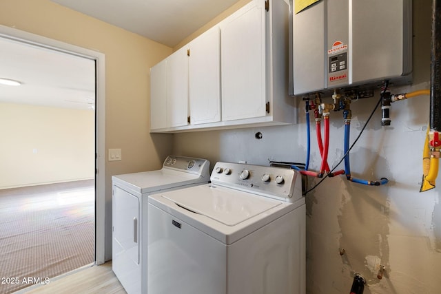 clothes washing area featuring cabinet space, water heater, and washing machine and clothes dryer