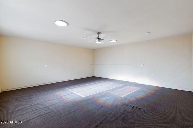 carpeted spare room with baseboards and a ceiling fan