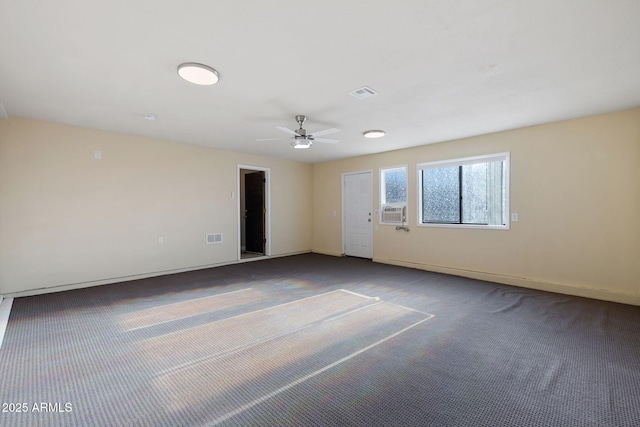 carpeted spare room with baseboards, visible vents, ceiling fan, and cooling unit