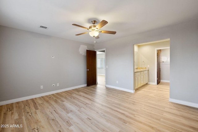 unfurnished bedroom with light wood finished floors, baseboards, visible vents, and connected bathroom