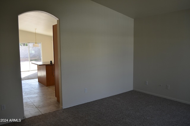 unfurnished room with light carpet and lofted ceiling