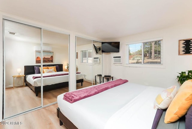 bedroom featuring a wall mounted AC and hardwood / wood-style flooring