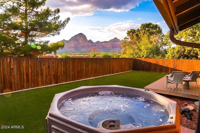 view of yard featuring a deck with mountain view and a hot tub