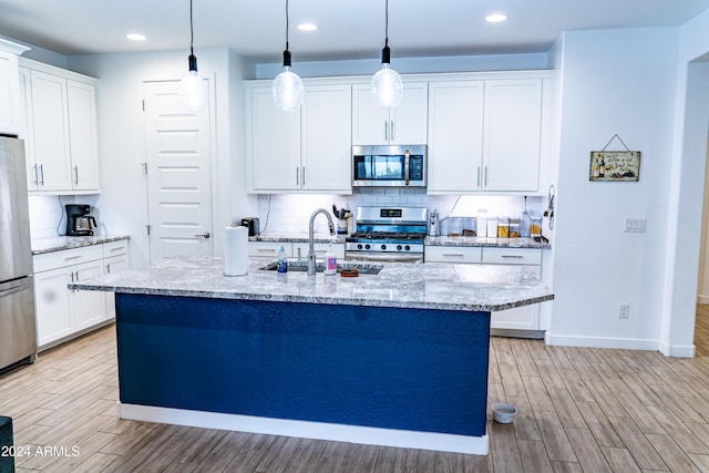 kitchen with light wood-type flooring, white cabinetry, sink, and appliances with stainless steel finishes