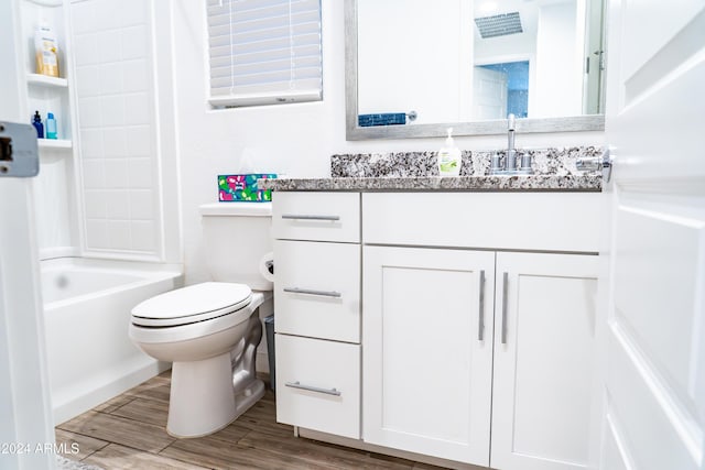 full bathroom featuring hardwood / wood-style floors, vanity, toilet, and tub / shower combination