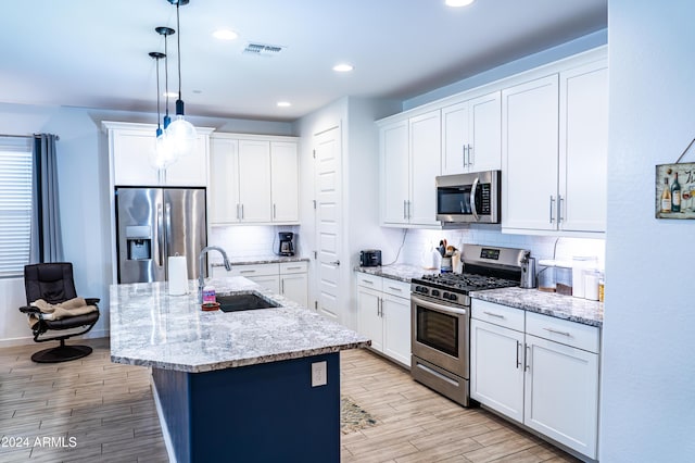 kitchen featuring white cabinetry, sink, decorative light fixtures, and appliances with stainless steel finishes