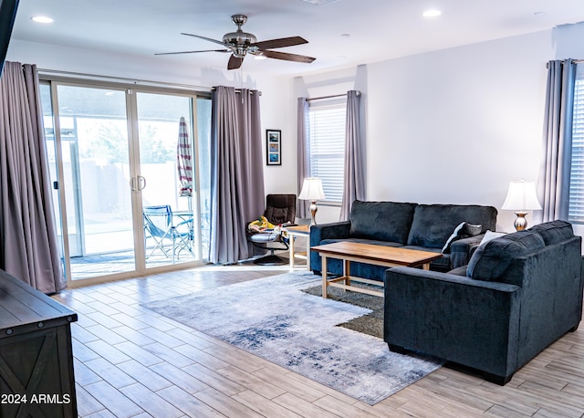 living room featuring ceiling fan and light hardwood / wood-style floors