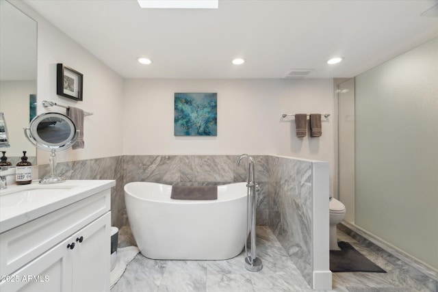 bathroom featuring vanity, toilet, and a bathing tub