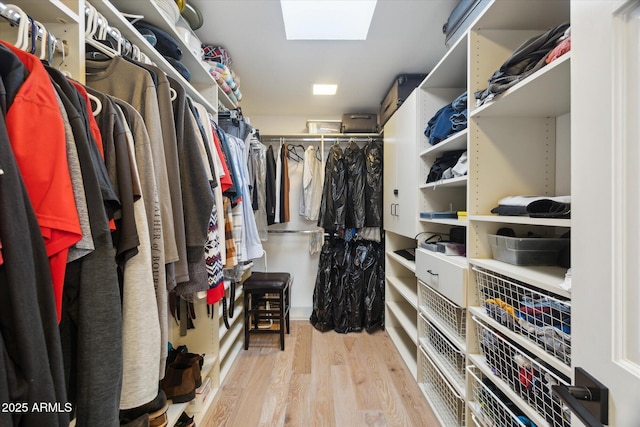 walk in closet with light hardwood / wood-style floors and a skylight