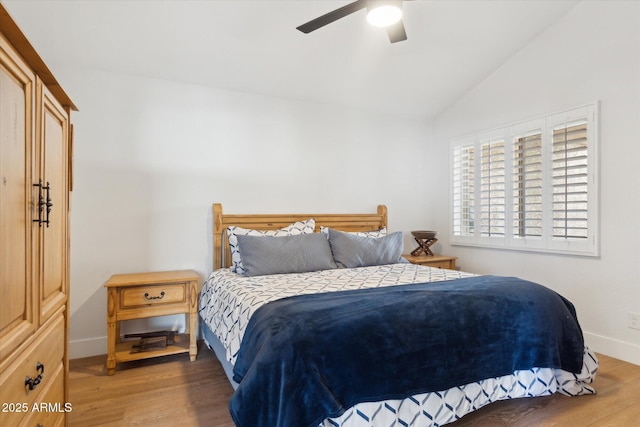 bedroom with ceiling fan, wood-type flooring, and vaulted ceiling