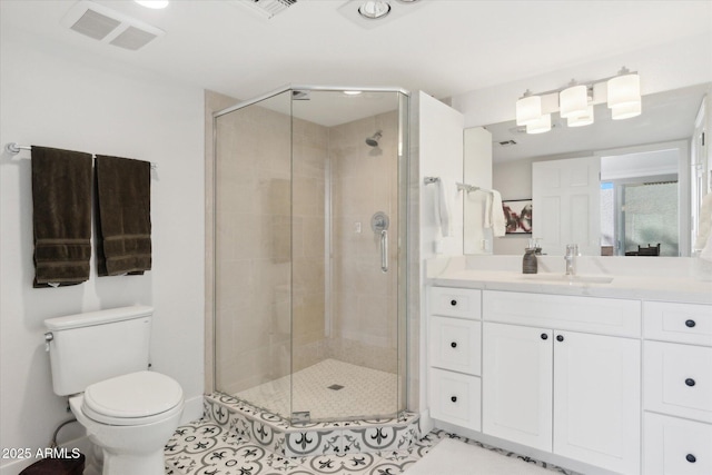 bathroom featuring vanity, tile patterned flooring, a shower with shower door, and toilet