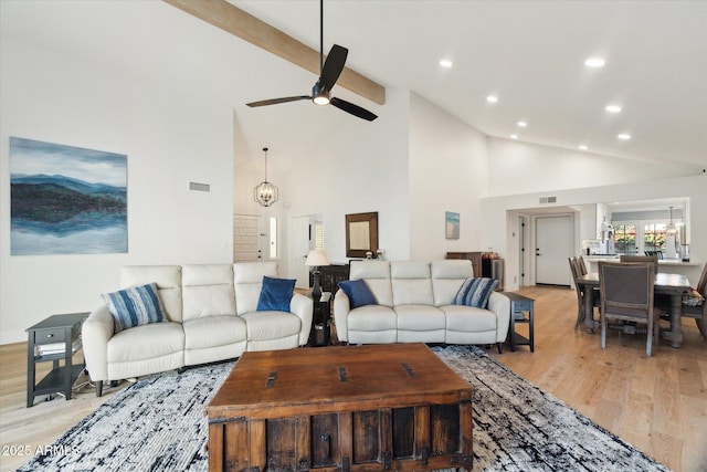 living room featuring beam ceiling, high vaulted ceiling, ceiling fan with notable chandelier, and light hardwood / wood-style floors